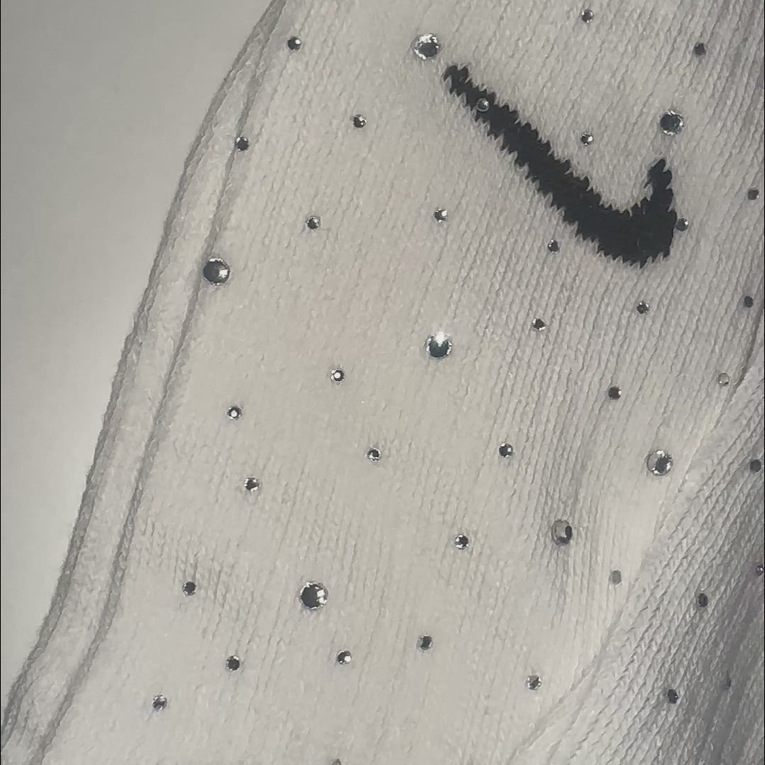 Makroaufnahme funkelnder Crystal-Rhinestones auf einer weißen Sportsocke – realistischer Glanz und präzise gesetzte Strassdetails.